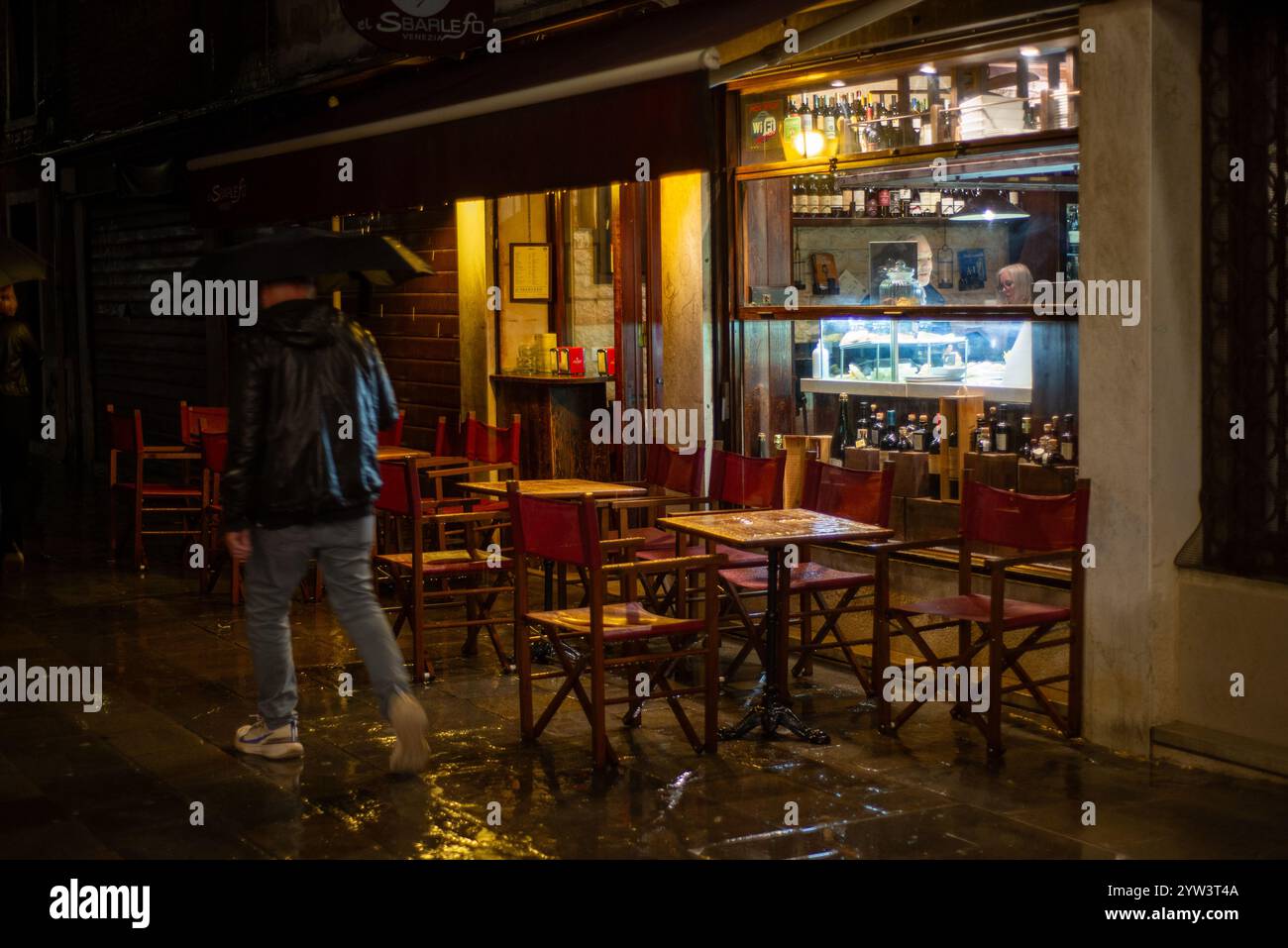 Ultima chiamata: Un paio di clienti hanno cercato rifugio dal trambusto in un bar nello storico quartiere di Cannaregio in una notte di pioggia. Foto Stock