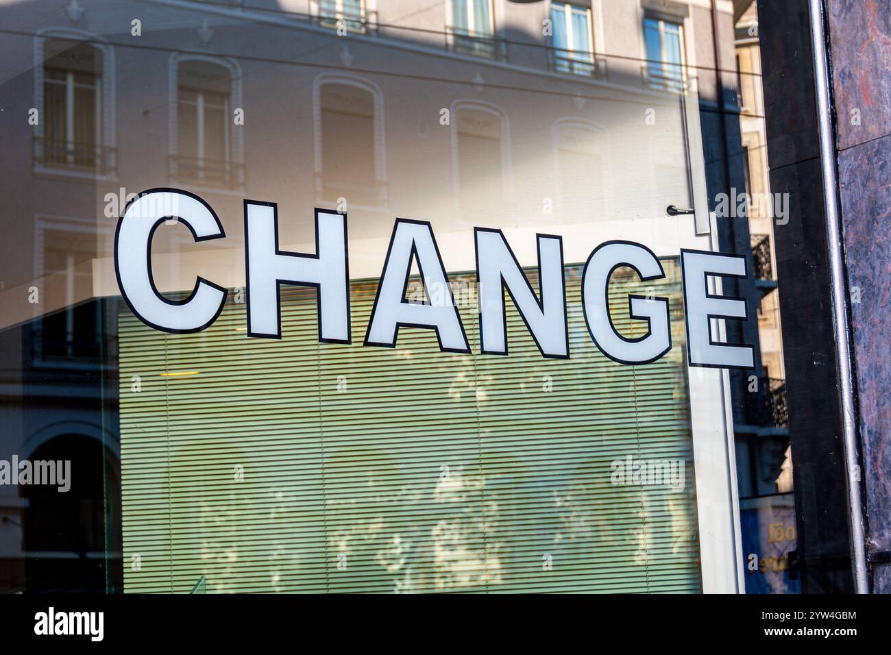 Primo piano di un cartello con la parola "CAMBIA" sulla finestra di un ufficio di cambio valuta, un'azienda in cui le persone possono scambiare una valuta con un'altra Foto Stock