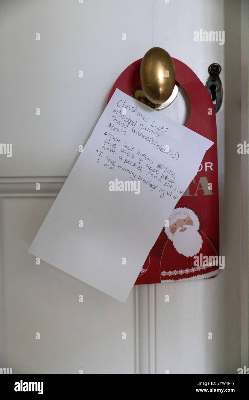 La lista di Natale è stata lasciata sulla maniglia della porta della camera da letto di un bambino prima delle festività natalizie, quando i bambini sperano di ottenere tutto ciò che desideravano. Foto Stock