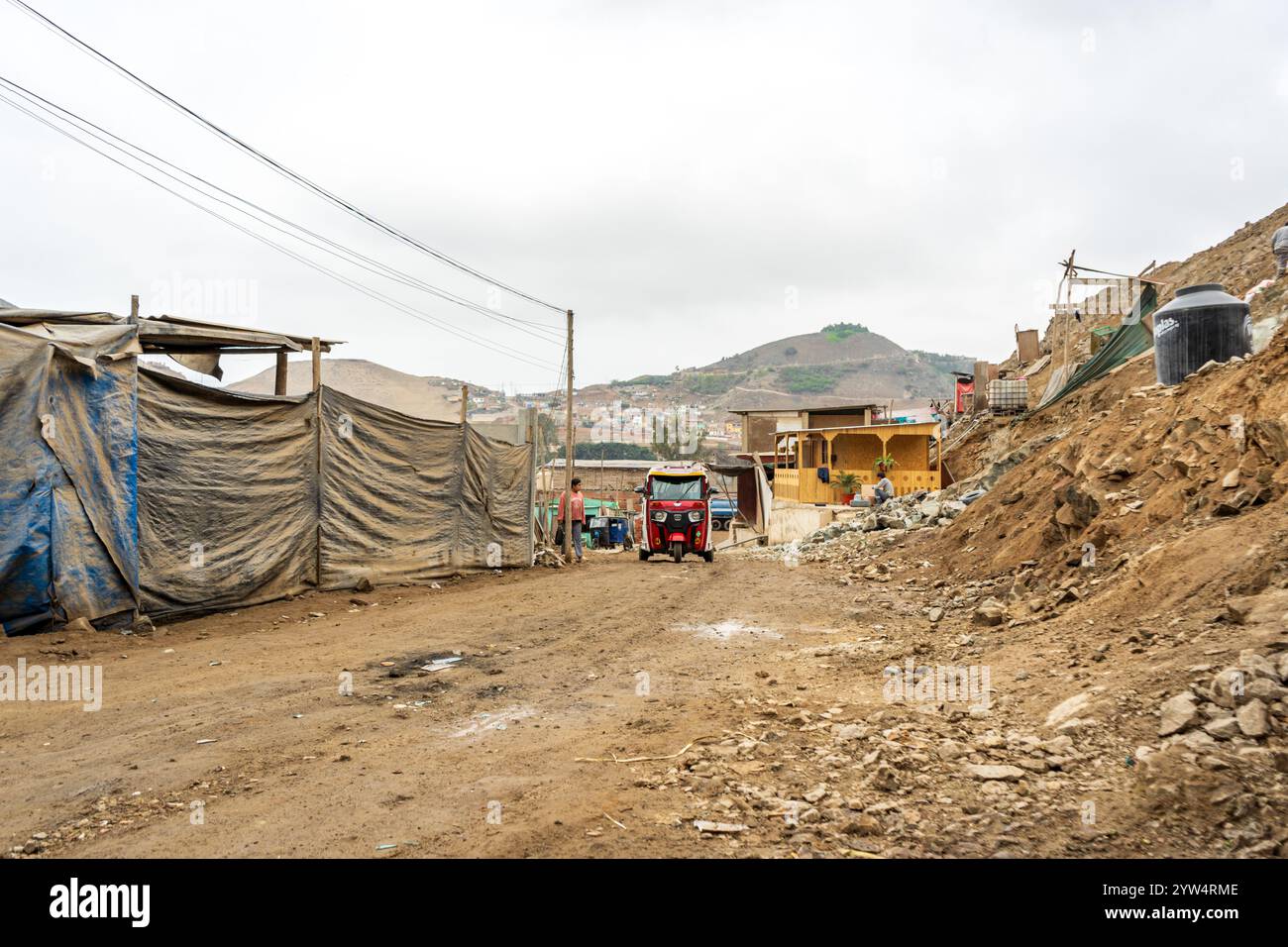 Lurin, Perù - 29 luglio 2023: Rural Street with TukTuk in a Dry Developing Neighborhood in the Mountains near Lima Foto Stock