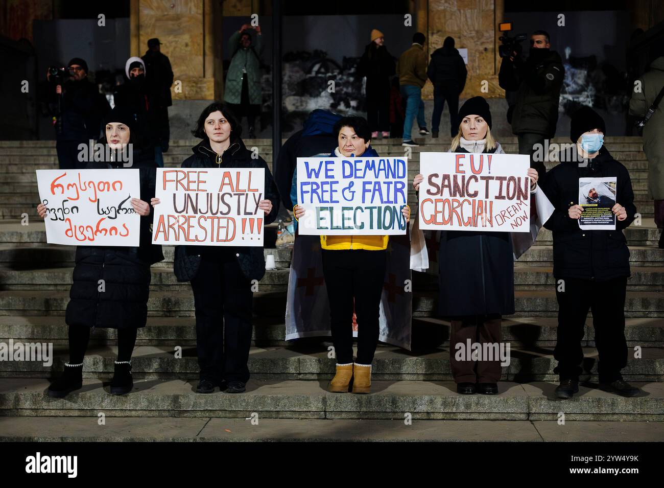 Jan Schmidt-Whitley/le Pictorium - manifestazione dell'opposizione a Tbilisi - 07/12/2024 - Georgia (Europa)/Tbilisi/Tbilisi - donne di fronte al parlamento georgiano con cartelli che chiedono elezioni libere, sanzioni contro la Georgia e il rilascio degli arrestati dall'inizio della protesta. I manifestanti contrari alla svolta filo-russa del governo di Irakli Kobakhidze stanno ora pattugliando le periferie dei raduni per contrastare gli attacchi da parte delle "titushka" (ausiliari civili pagati dal governo per attaccare e terrorizzare gli avversari). I manifestanti si sono riuniti di fronte al Georg Foto Stock