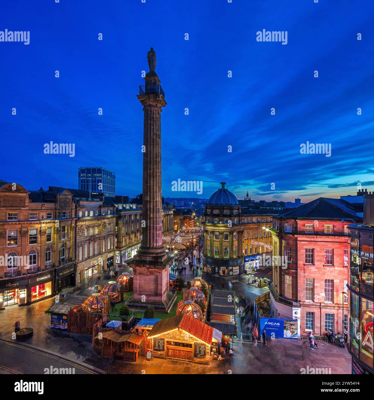 Vista al crepuscolo durante il periodo natalizio guardando il Grey's Monument a Newcastle upon Tyne verso il mercatino di natale con le luci natalizie Foto Stock