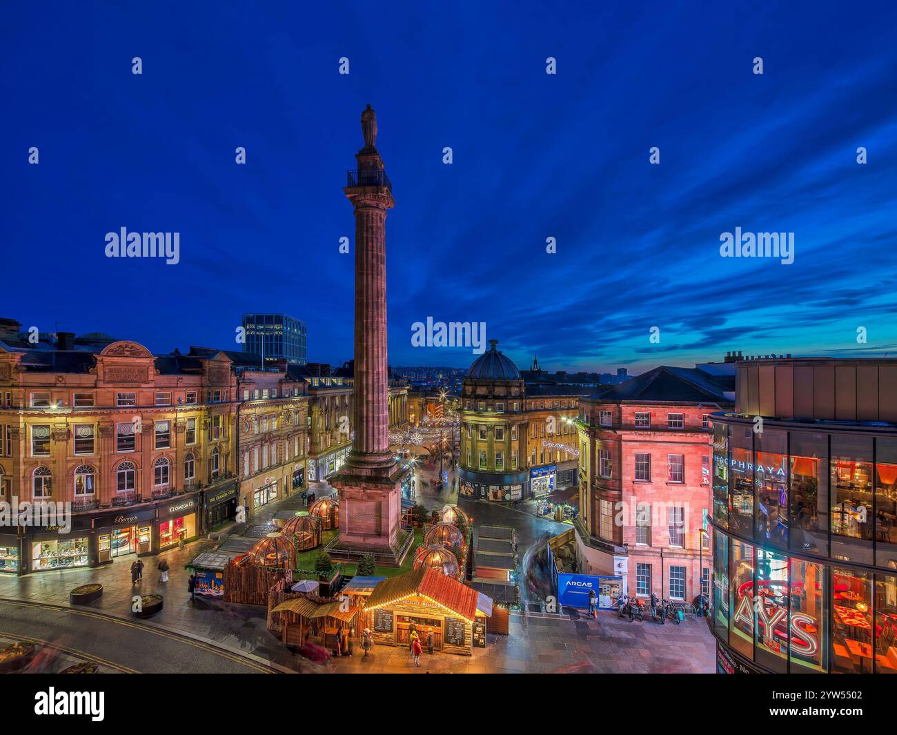 Vista al crepuscolo durante il periodo natalizio guardando il Grey's Monument a Newcastle upon Tyne verso il mercatino di natale con le luci natalizie Foto Stock
