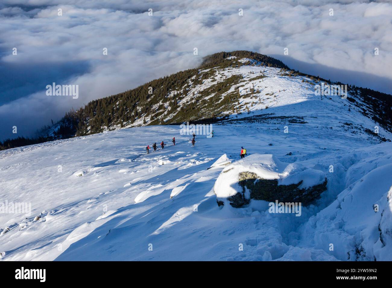 Escursionisti in montagna su un crinale alto sopra le rive nuvolose nelle vallate sottostanti, Carpazi Foto Stock