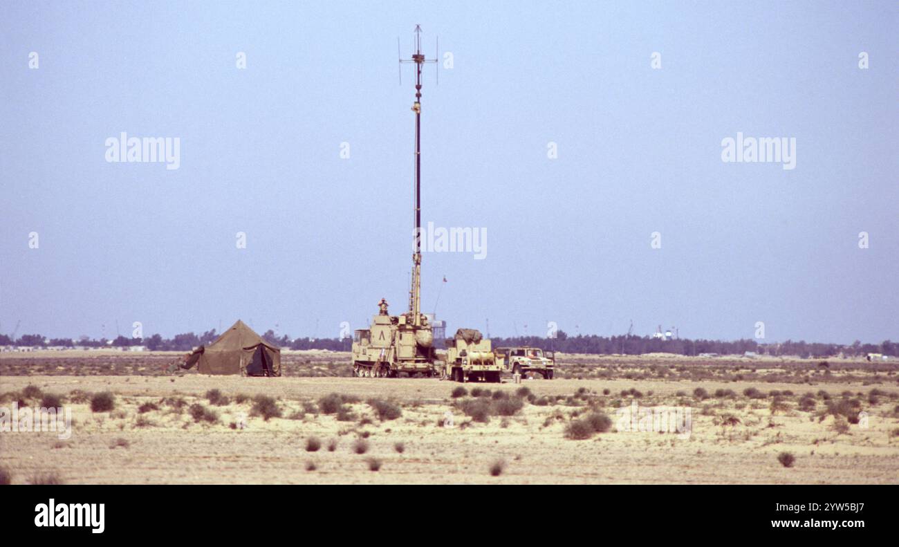 Prima guerra del Golfo: 17 marzo 1991 postazione mobile per comunicazioni radio dell'esercito degli Stati Uniti, vicino al confine con l'Iraq nel nord del Kuwait. Un massiccio albero telescopico dell'antenna è fissato a un veicolo cingolato M548. Le gru al porto di um Qasr sono visibili sullo sfondo. Foto Stock