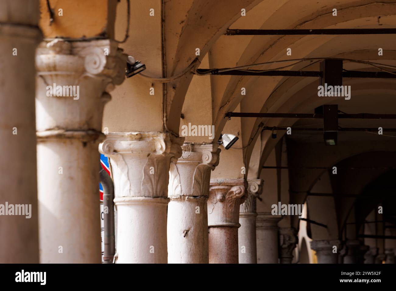 Una vista panoramica di un colonnato con capitelli corinzi nel centro storico di Mantova, evidenziando la bellezza architettonica della città. Foto Stock