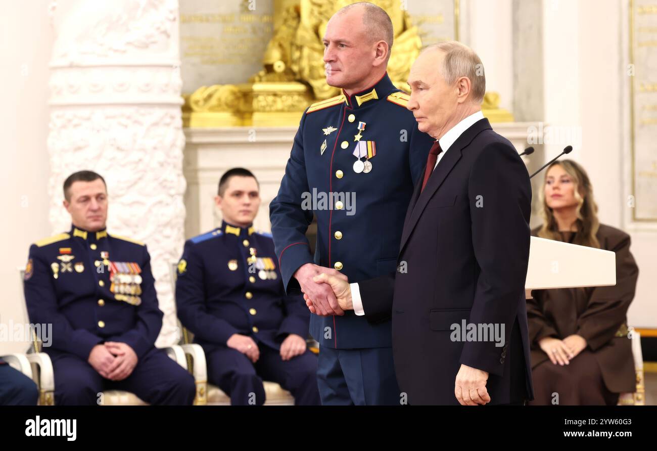 Mosca, Russia. 9 dicembre 2024. Il presidente russo Vladimir Putin, conferisce la medaglia d'oro all'eroe della Russia, al comandante dei carri armati tenente Denis Raspopov, durante una cerimonia per celebrare la giornata degli Eroi della Patria nella sala di San Giorgio del Gran Palazzo del Cremlino, il 9 dicembre 2024 a Mosca, in Russia. Crediti: Alexander Kazakov/piscina del Cremlino/Alamy Live News Foto Stock