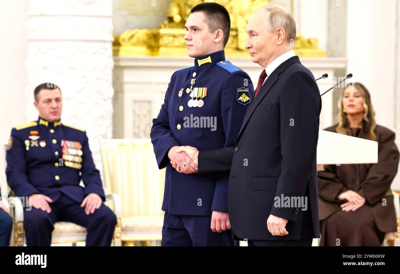 Mosca, Russia. 9 dicembre 2024. Il presidente russo Vladimir Putin, conferisce la medaglia d'oro all'eroe della Russia, al privato Alexey Asylkhanov, durante una cerimonia in occasione della giornata degli Eroi della Patria nella sala di San Giorgio del Gran Palazzo del Cremlino, il 9 dicembre 2024 a Mosca, Russia. Crediti: Alexander Kazakov/piscina del Cremlino/Alamy Live News Foto Stock