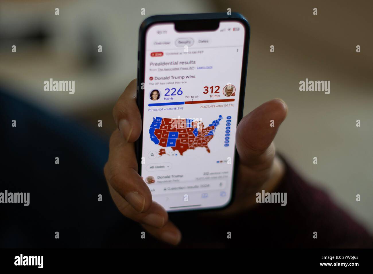 Un elettore si aggira sui risultati finali delle elezioni presidenziali statunitensi su un iPhone. Donald Trump ha vinto le elezioni, vincendo 30 stati con 312 elettorali... Foto Stock