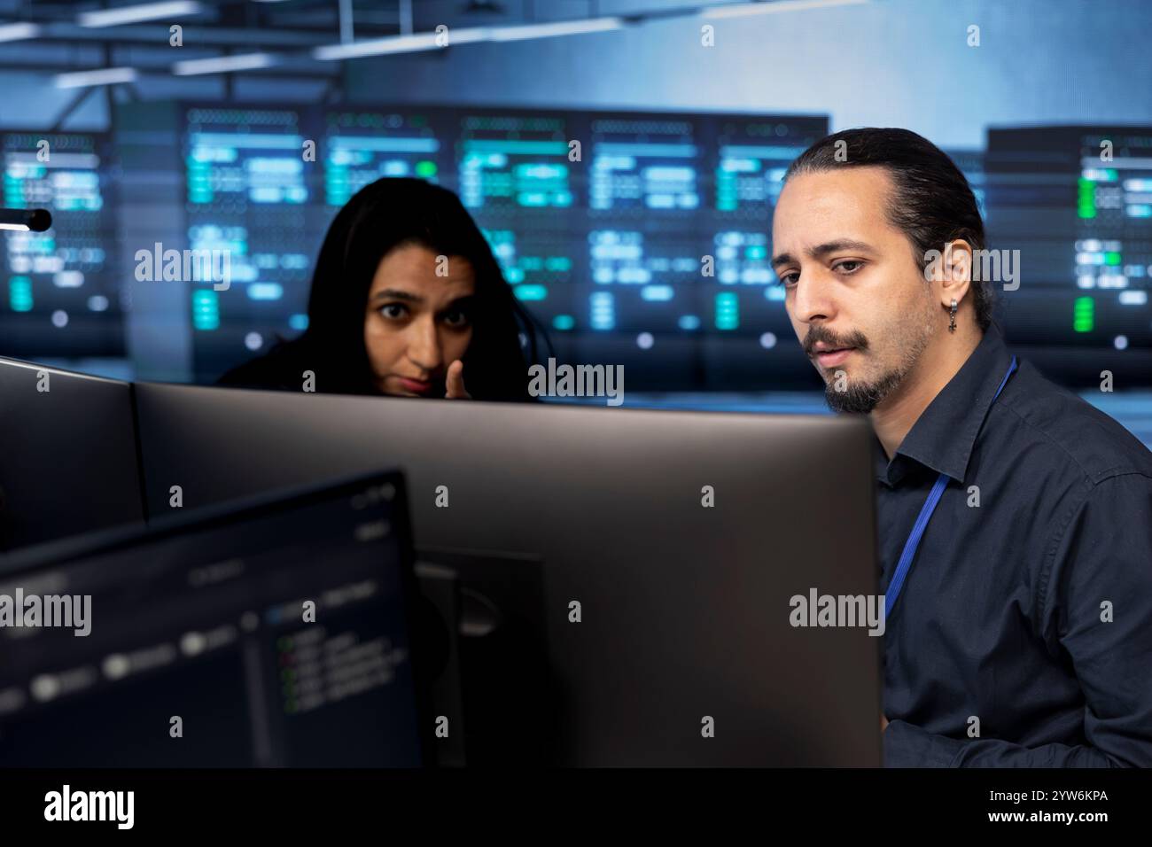Ingegneri che riconfigurano server farm per ottimizzarla in base alle esigenze di elaborazione dei dati dei clienti. Professionisti IT che garantiscono un funzionamento efficiente delle apparecchiature per data center Foto Stock