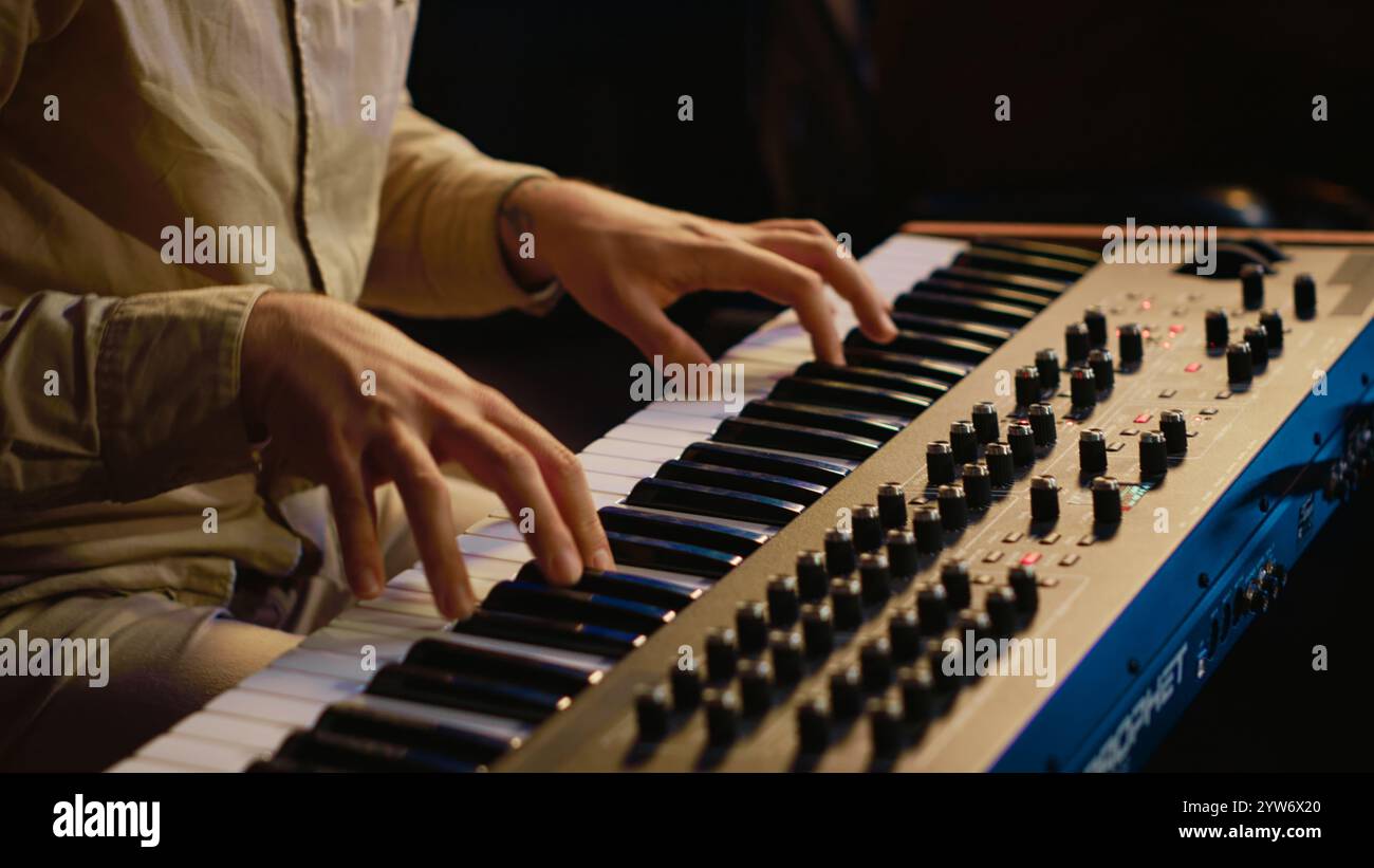 Artista di talento che si esibisce in sala di controllo in studio e registra musica per il nuovo album, lavorando con console di mixaggio e fader motorizzati. Musicista che compone nuovi brani su equipaggiamento tecnico. Telecamera A.. Foto Stock