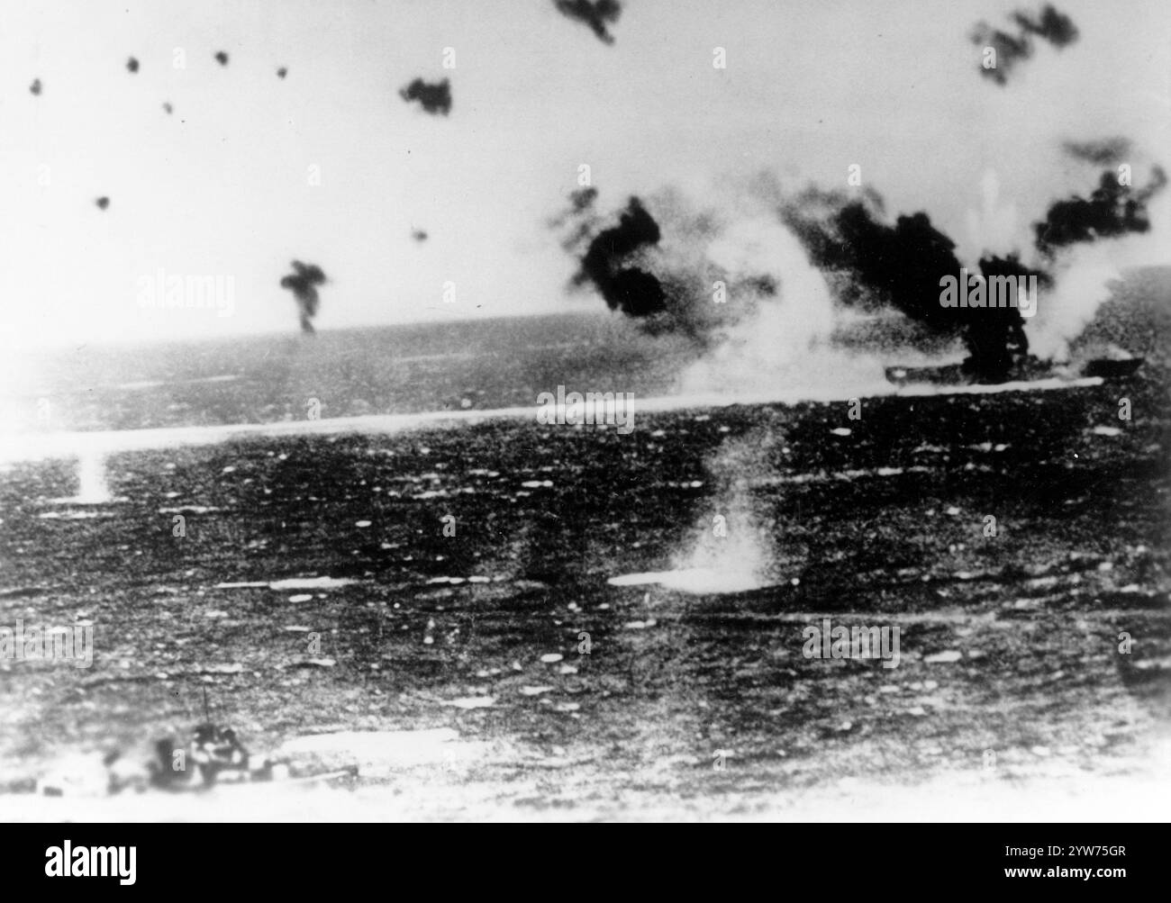 Battaglia del Mar dei Coralli, maggio 1942 USS Lexington (CV-2) sotto attacco aereo l'8 maggio 1942, come fotografato da un aereo giapponese. Il forte fumo nero dalla pila e il fumo bianco dal suo arco indicano che la vista è stata scattata subito dopo che quelle aree sono state colpite dalle bombe. Il Destroyer in basso a sinistra sembra essere USS Phelps (DD-360) Foto Stock