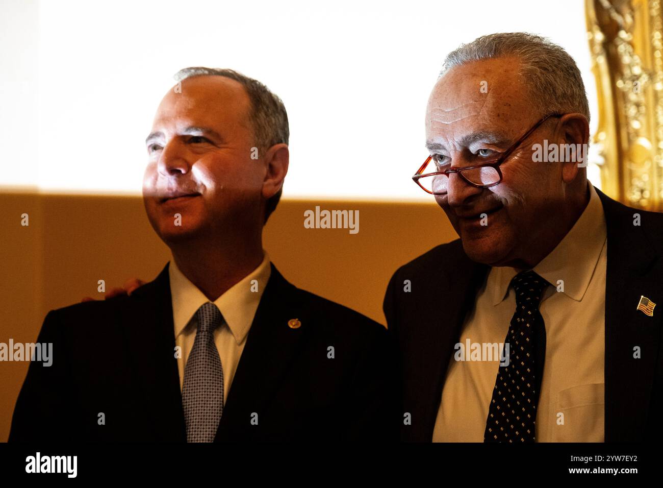 Washington, Stati Uniti. 9 dicembre 2024. Il senatore Chuck Schumer (D-N.Y.), il leader della maggioranza del Senato, a destra, e il senatore Adam Schiff (D-CA), a sinistra, sono parzialmente illuminati dal flash di un fotografo dopo che il senatore Schiff ha prestato giuramento, al Campidoglio degli Stati Uniti, a Washington, DC, lunedì 9 dicembre, 2024. (Graeme Sloan/Sipa USA) credito: SIPA USA/Alamy Live News Foto Stock