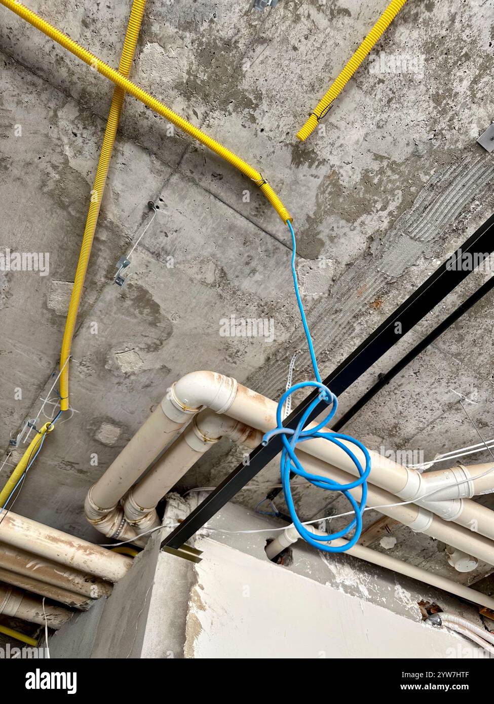 Installazione a soffitto con tubi e conduttori nel cantiere edile Foto Stock