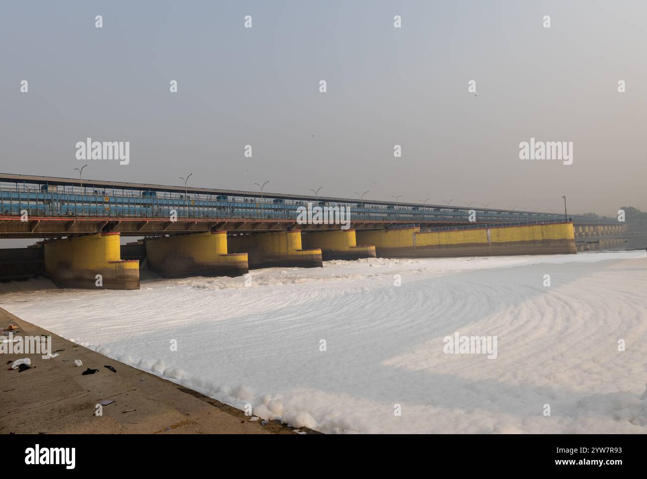 fiume inquinato con effluenti industriali e domestici schiuma tossica e ponte stradale al mattino l'immagine viene scattata presso lo sbarramento del fiume yamuna di okhla delhi india. Foto Stock