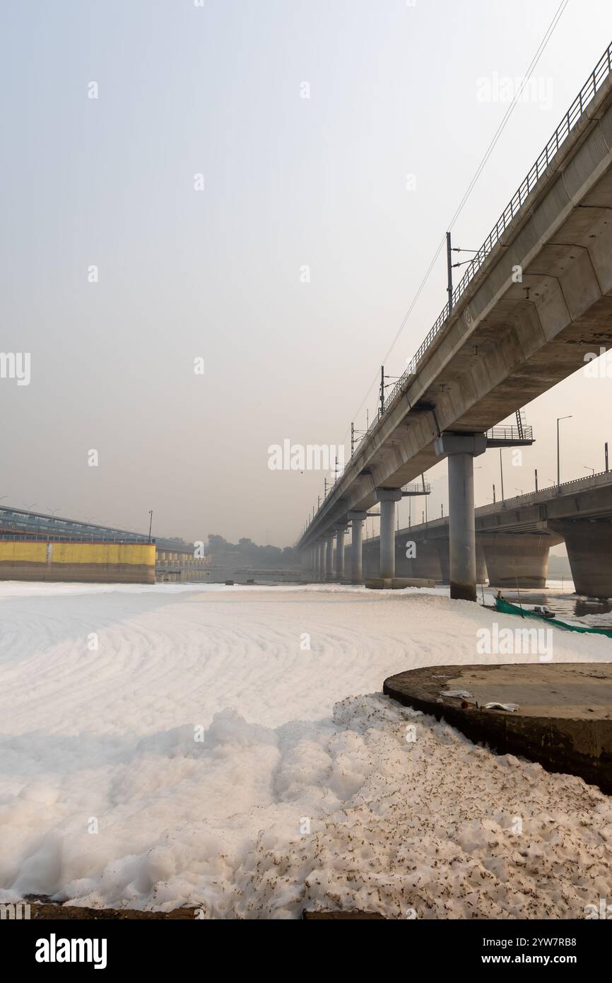 fiume inquinato con effluenti industriali e domestici schiuma tossica e ponte stradale al mattino l'immagine viene scattata presso lo sbarramento del fiume yamuna di okhla delhi india. Foto Stock