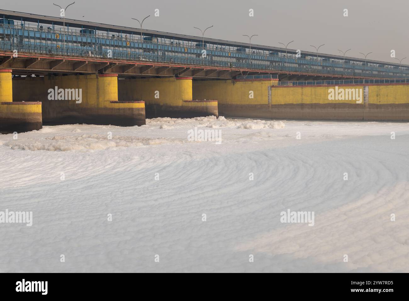 fiume inquinato con effluenti industriali e domestici schiuma tossica e ponte stradale al mattino l'immagine viene scattata presso lo sbarramento del fiume yamuna di okhla delhi india. Foto Stock