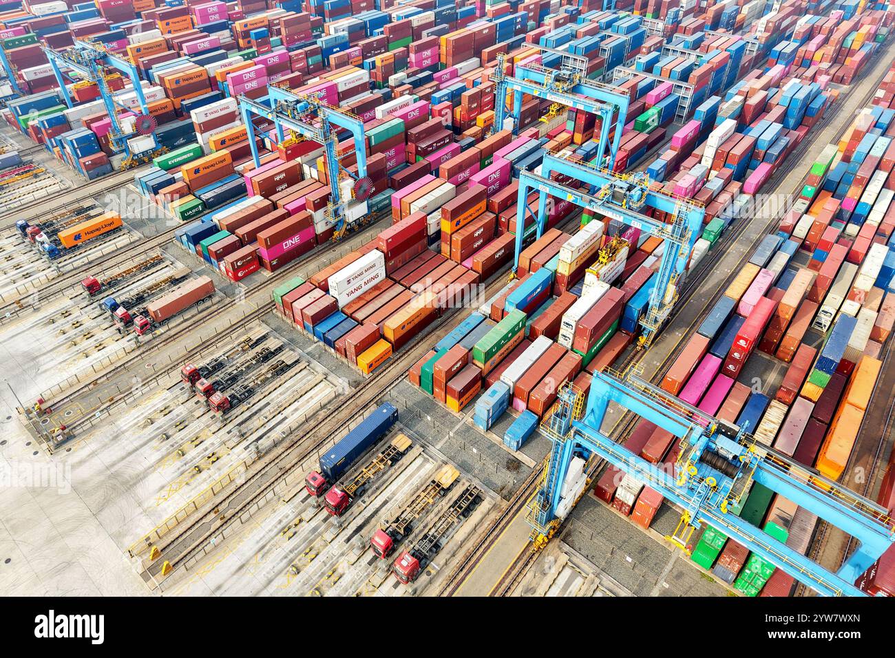 QINGDAO, CINA - 10 DICEMBRE 2024 - i veicoli trasportano container per il commercio estero in un terminal completamente automatizzato nel porto di Qingdao, nello Shandong della Cina orientale Foto Stock