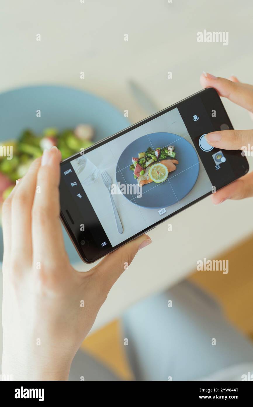 Donne che scattano foto del loro pasto con uno smartphone Foto Stock