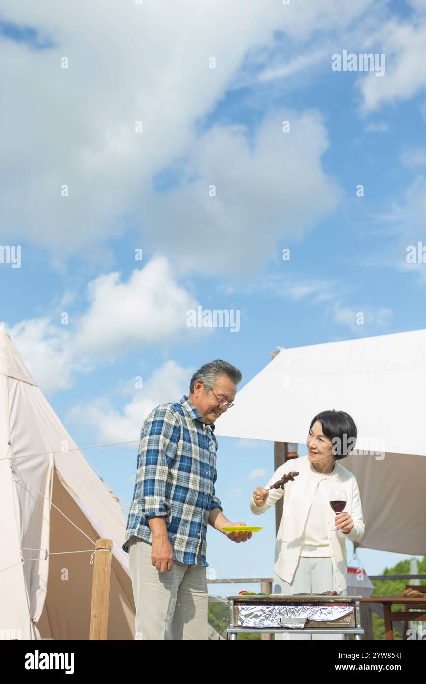 Coppia senior che si gode un barbecue Foto Stock