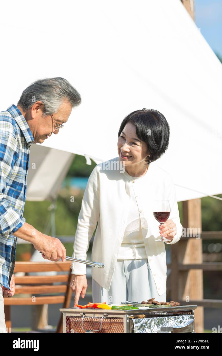 Coppia senior che si gode un barbecue Foto Stock