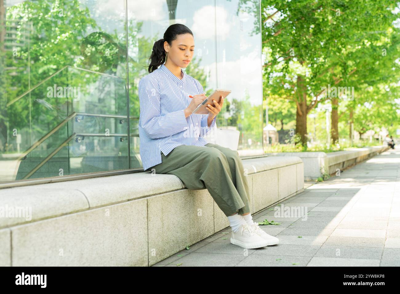 Metà donna che utilizza un tablet all'aperto Foto Stock