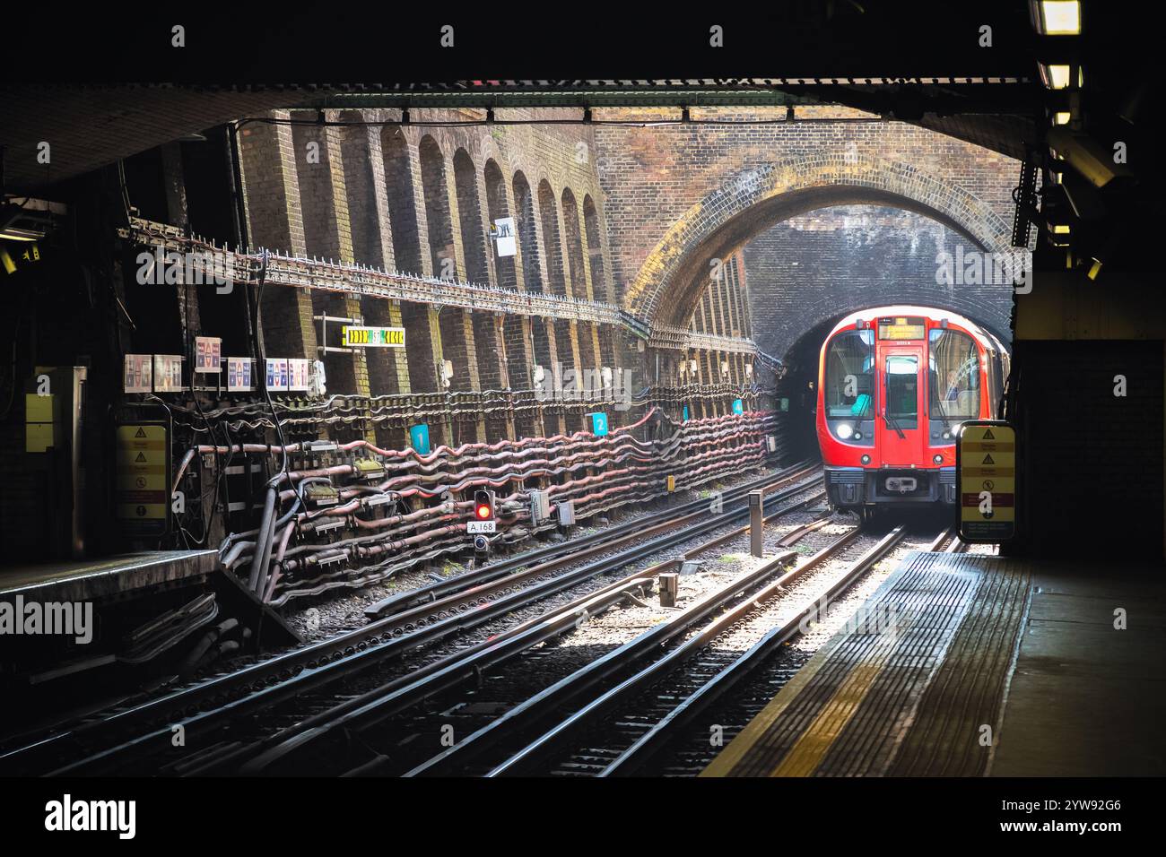 Un treno della linea Circle sotto la superficie che si avvicina alla piattaforma della stazione della metropolitana di Bayswater a Londra, Regno Unito Foto Stock