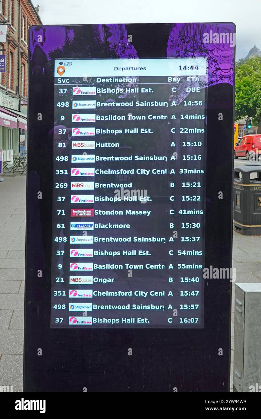 Gli orari dell'autobus di partenza sono elencati e aggiornati sulla bacheca fornita dal Consiglio della contea di Essex sul marciapiede accanto alla trafficata fermata dell'autobus Brentwood Essex Inghilterra Regno Unito Foto Stock