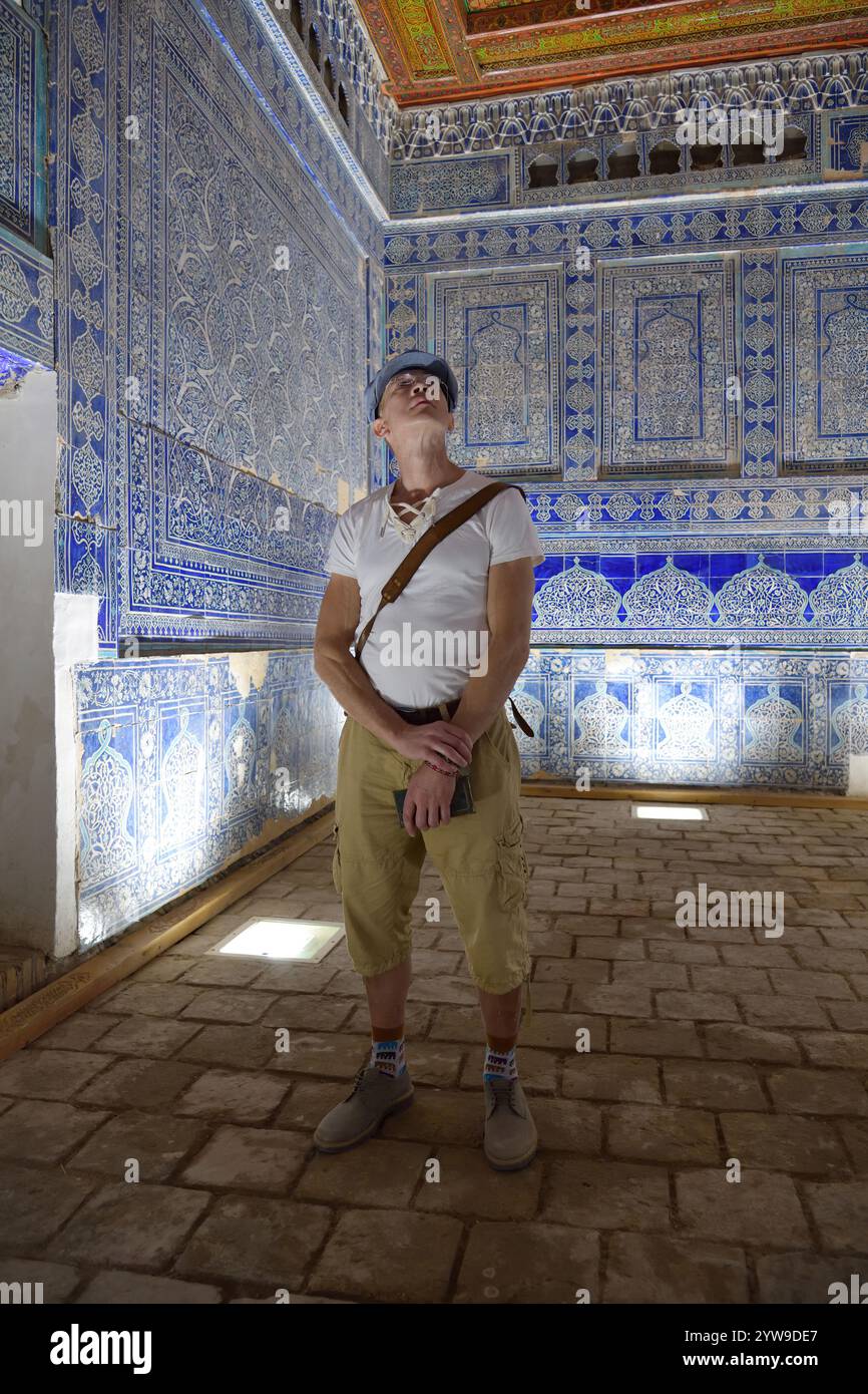 Turista nel soggiorno di Harem nell'antico palazzo khan noto anche come Tosh Hovli o Palazzo Tash Khauli a Khiva. Uzbekistan Foto Stock