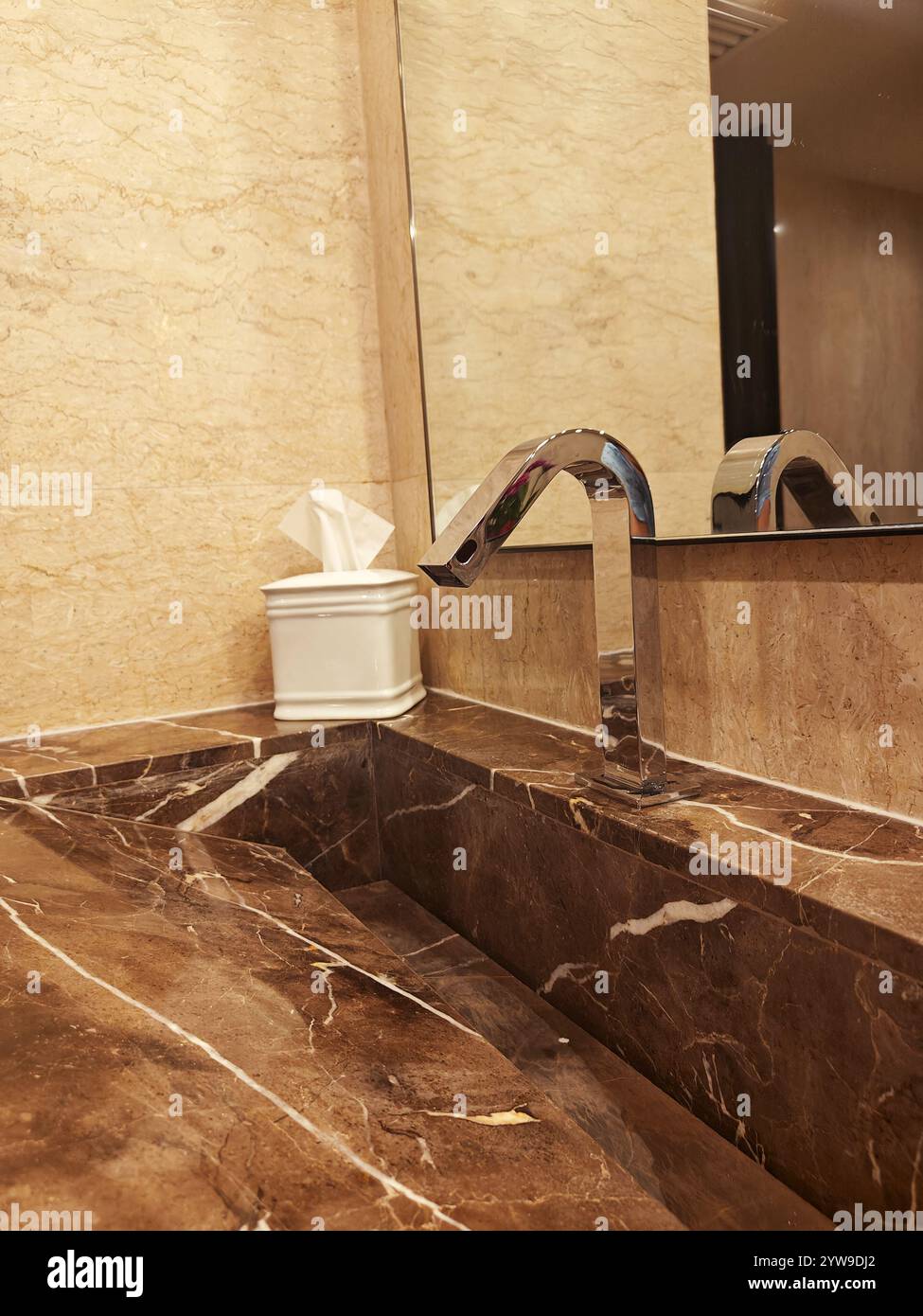 Bagno lussuoso con marmo lucido, rubinetto moderno e portasciugamani ben disposti per la massima comodità. Foto Stock