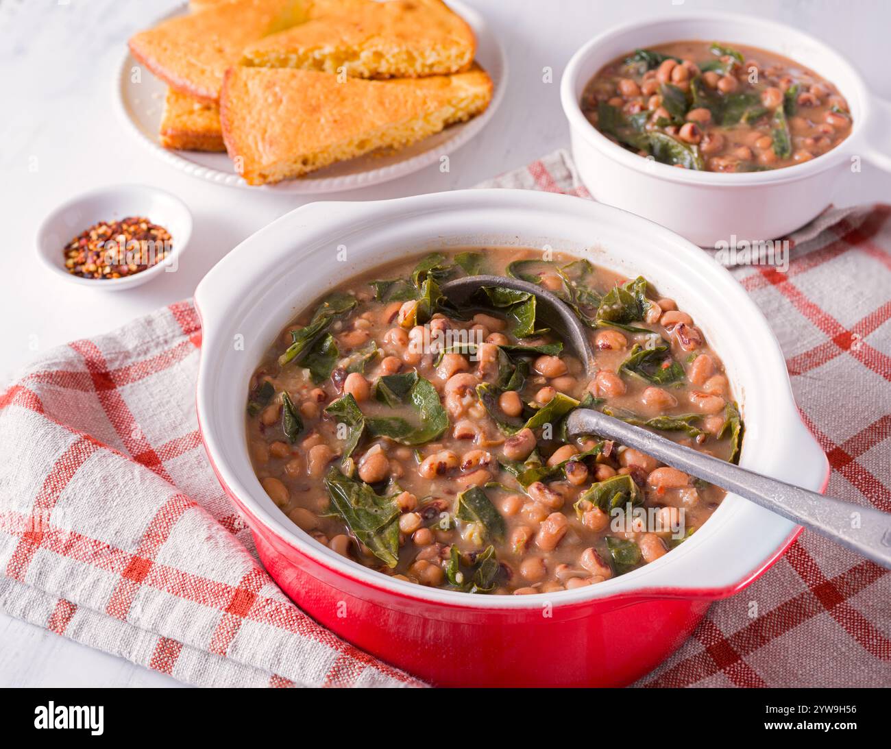 Piatto del sud DEGLI STATI UNITI con piselli dagli occhi neri e verdure al colletto e pane di mais a lato Foto Stock