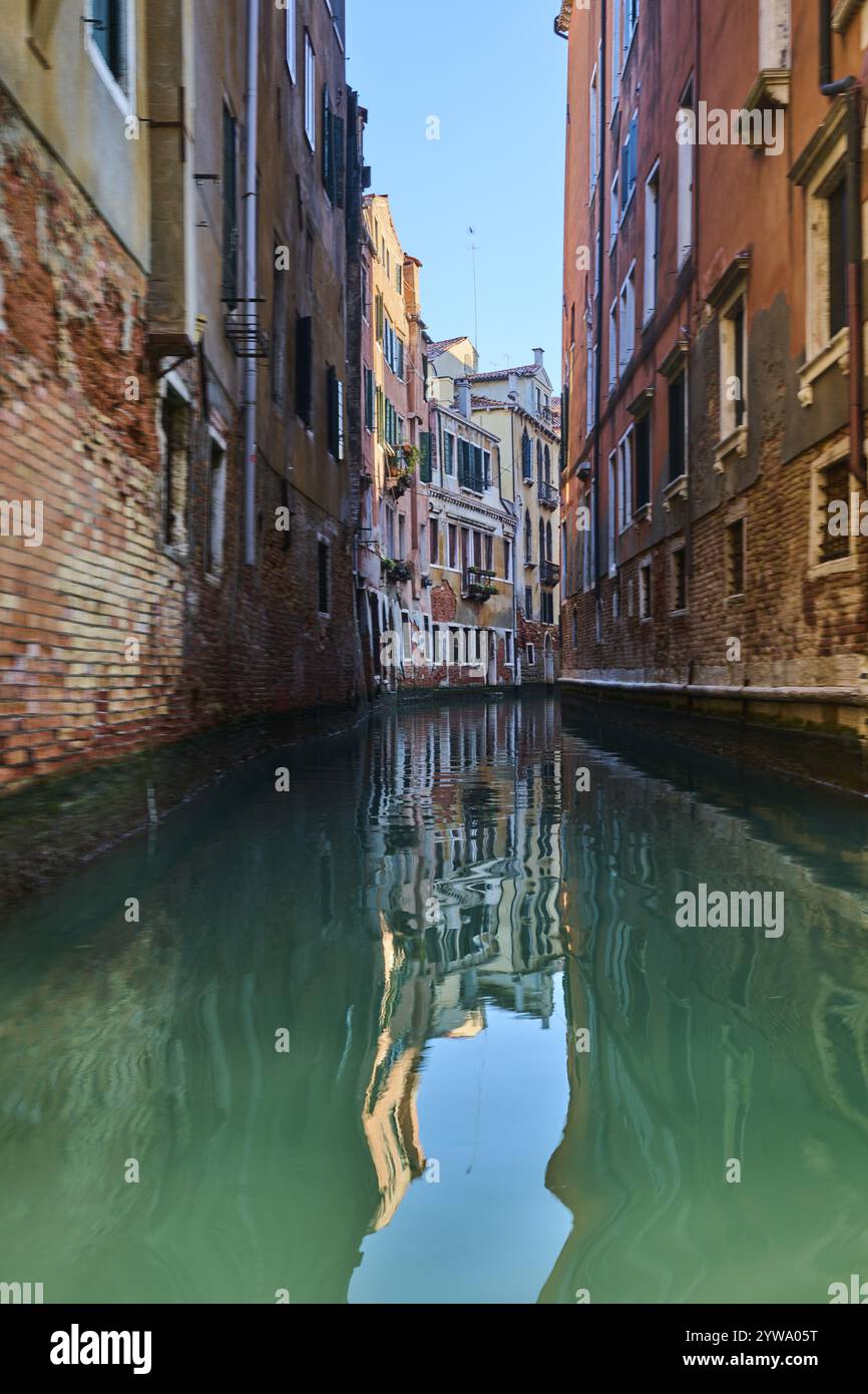 Vista da una gondola su un corso d'acqua a Venezia passando attraverso le case in una tranquilla e soleggiata mattinata d'inverno, Italia, Europa Foto Stock