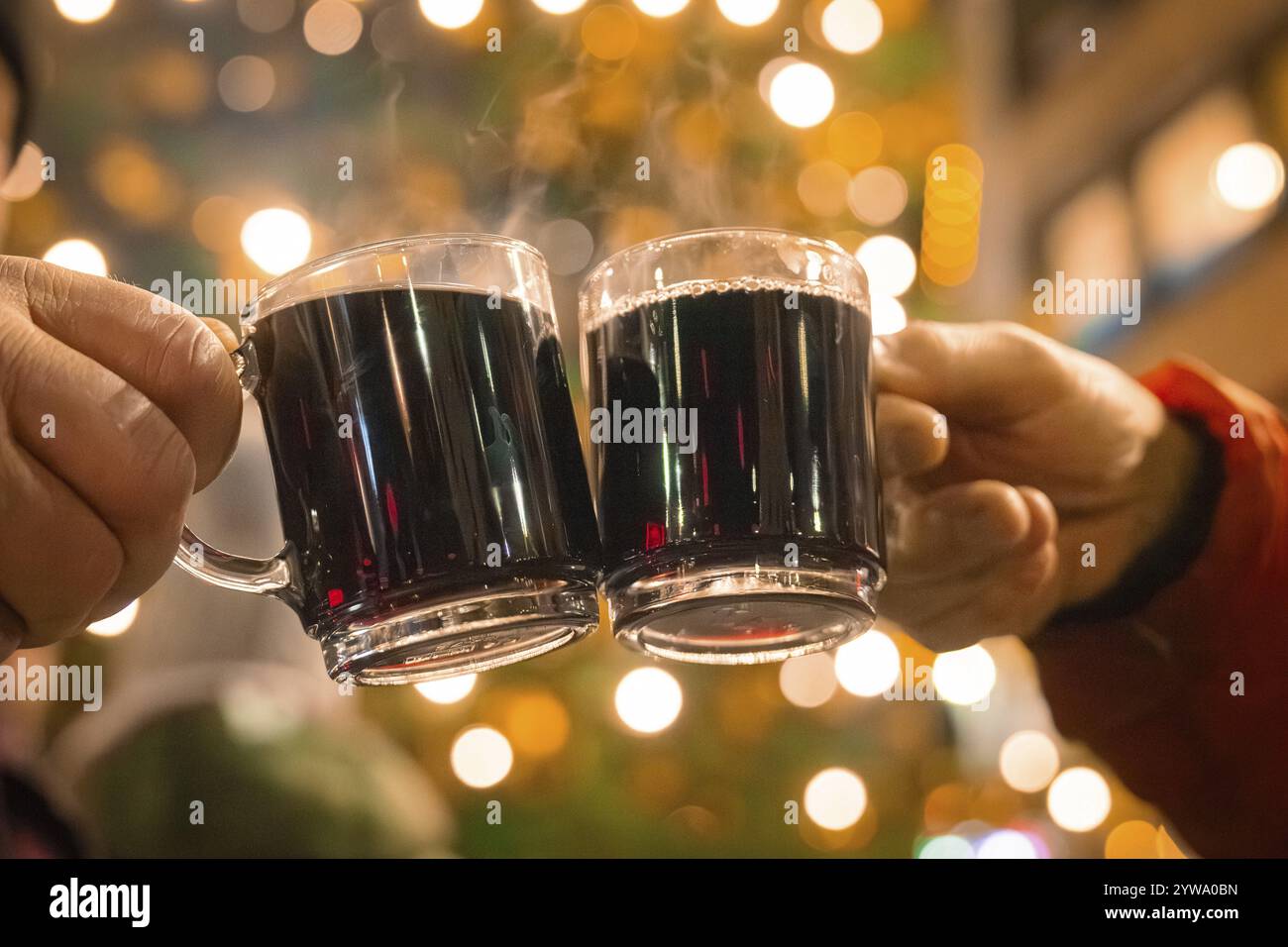 Due mani che reggono tazze di VIN brulé in una notte di festa con luci, Lichternacht Fest, Nagold, Foresta Nera, Germania, Europa Foto Stock