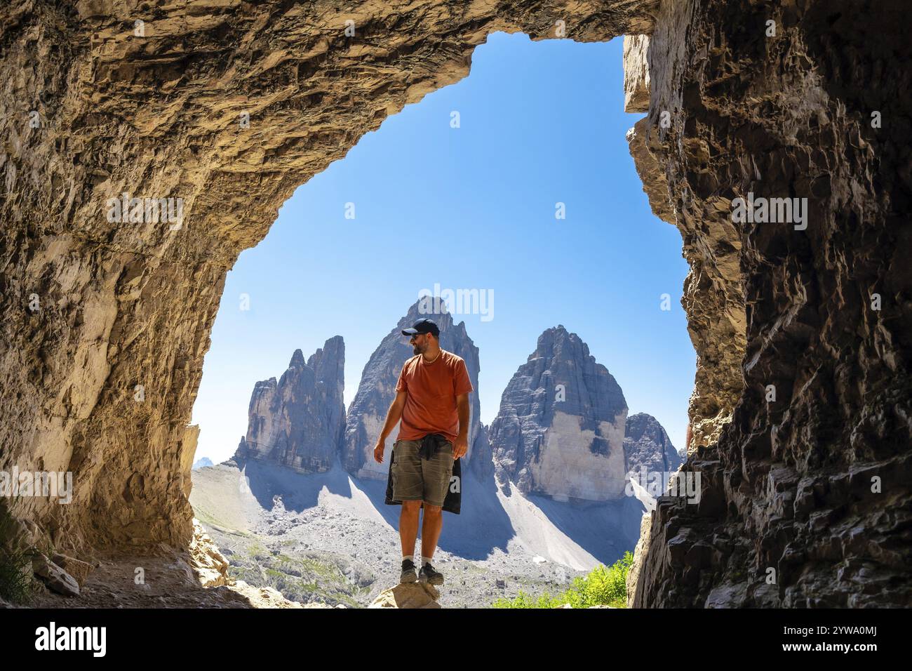 Escursione con vista panoramica sulle tre cime di lavaredo, simbolo delle dolomiti, dall'interno di una grotta delle tre Cime durante un'escursione estiva Foto Stock