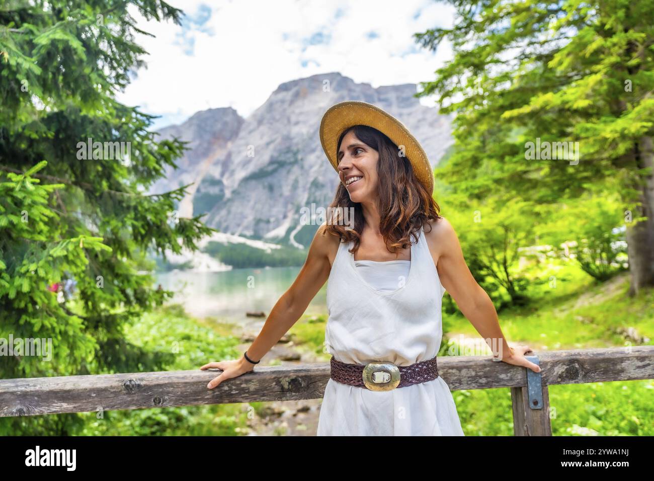 Donna che indossa un cappello di paglia che gode del paesaggio del lago di braies, chiamato anche pragser wildsee, durante le vacanze estive nelle dolomiti Foto Stock