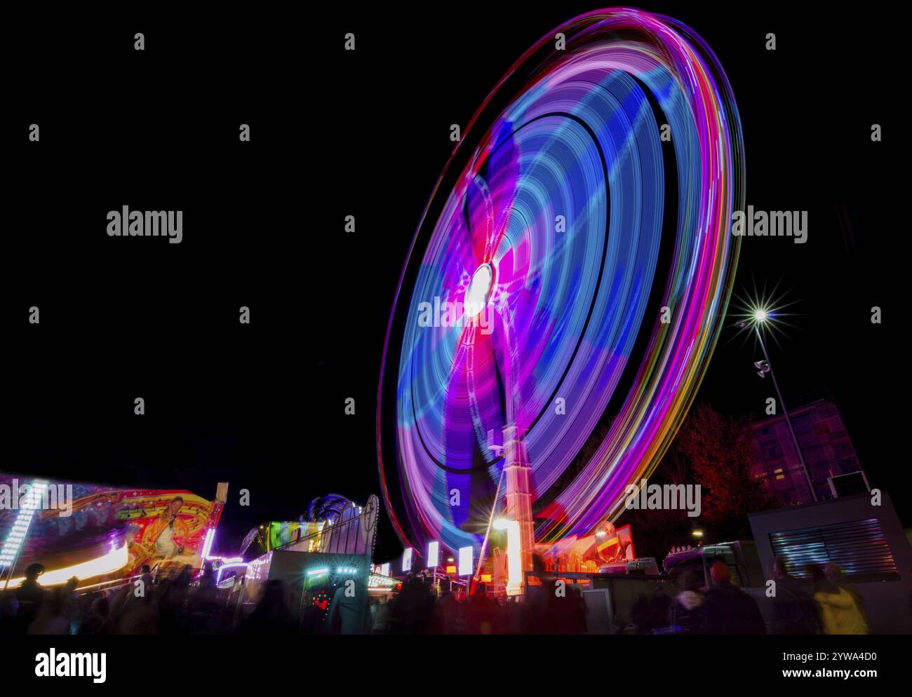 Graz, Austria - 05 ottobre 2019: Ruota panoramica in movimento nel parco divertimenti, di notte. Fotografia a lunga esposizione. Foto Stock