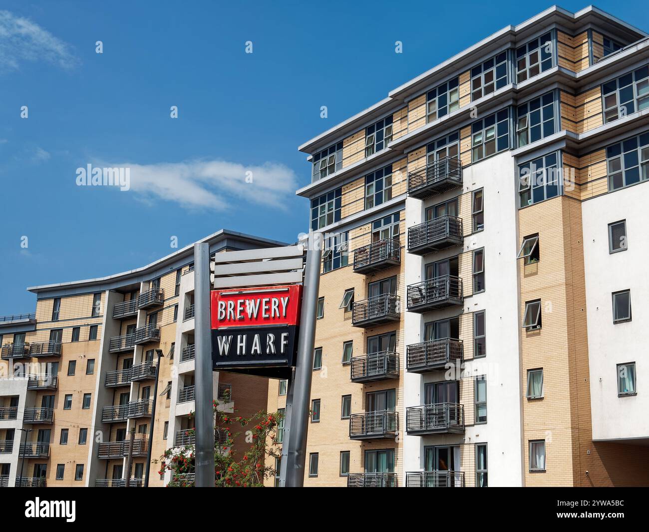 UK, West Yorkshire, Leeds, Brewery Wharf Sign e Apartment Buildings. Foto Stock
