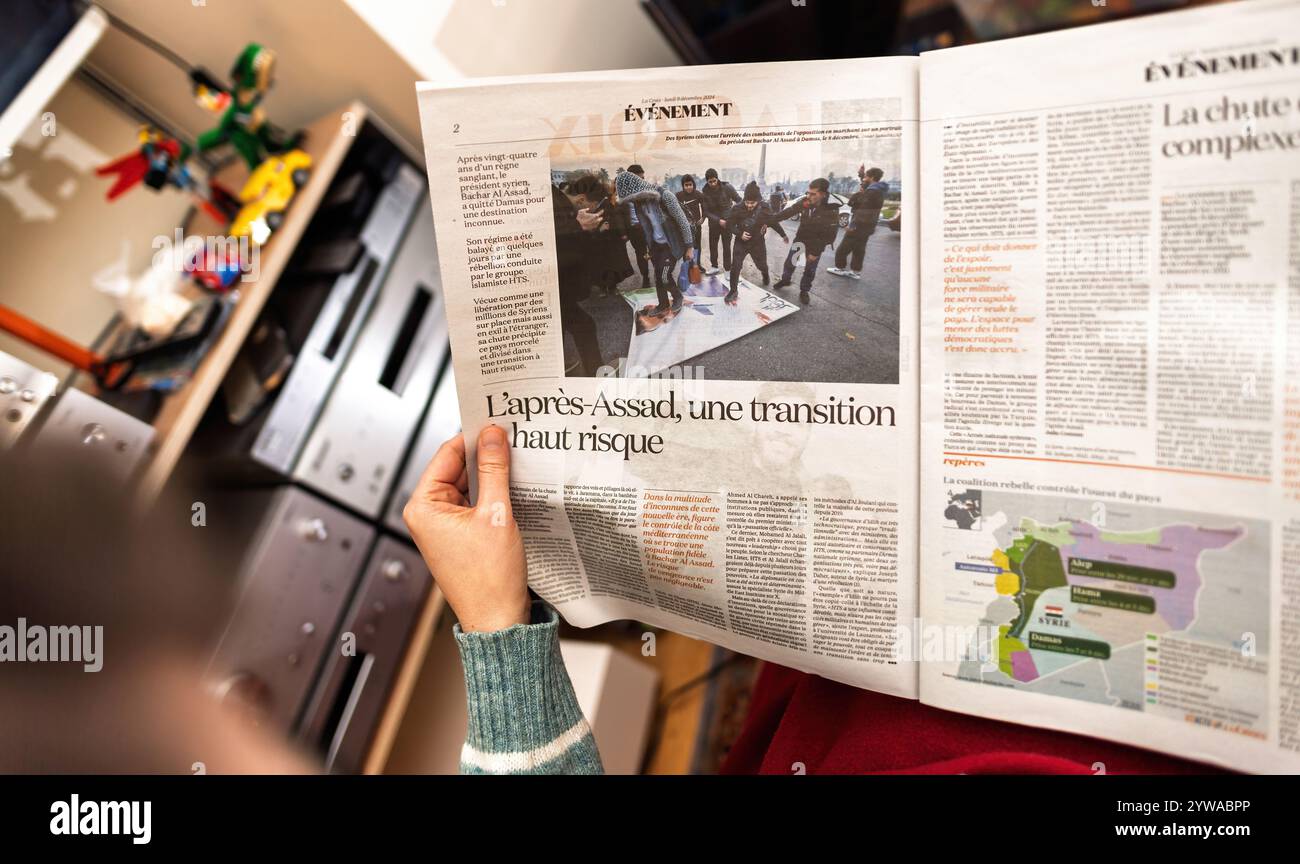 Parigi, Francia - 9 dicembre 2024: Persona che legge il giornale la Croix con un articolo intitolato l'apres-Assad, une transition haut risque, che discute della transizione ad alto rischio della Siria dopo Assad Foto Stock