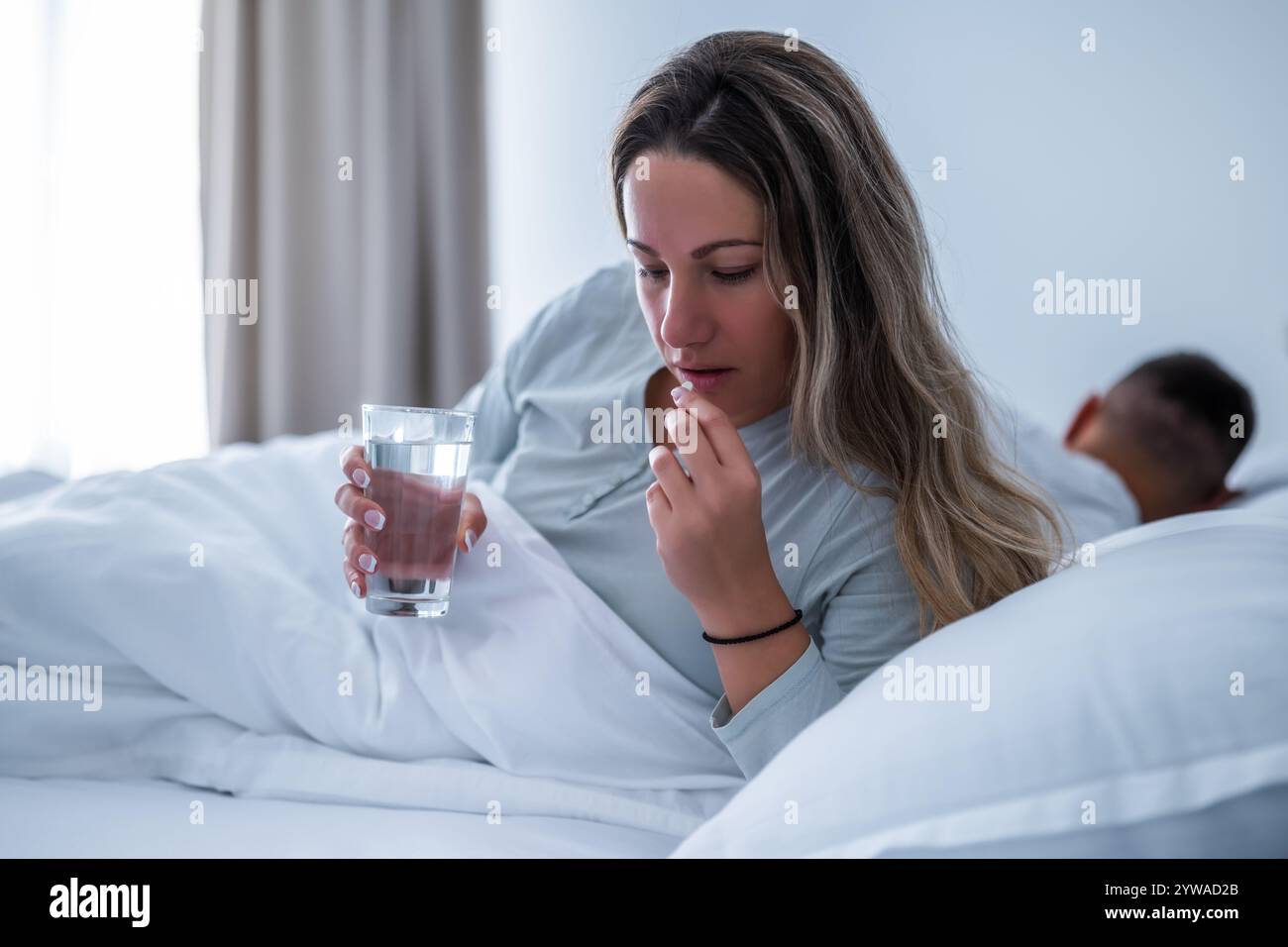 La donna non riesce a dormire. Sta prendendo pillole per dormire. Foto Stock