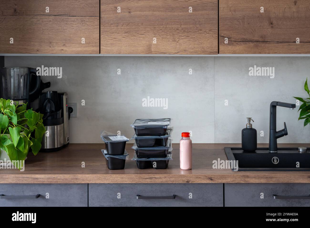 Scatole nere con un programma di dieta sana per la perdita di peso, consegna del menu giornaliero dei pasti pronti. Cibo ordinato con l'app per telefono cellulare. Porzione bilanciata con piatto Foto Stock