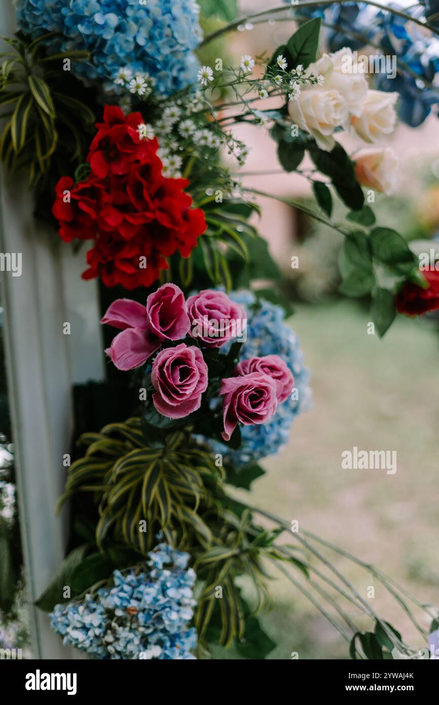 Fiori artificiali disposti come decorazioni nuziali, che aggiungono colori vivaci ed eleganza alla celebrazione, perfetti per valorizzare temi e ambientazioni nuziali Foto Stock