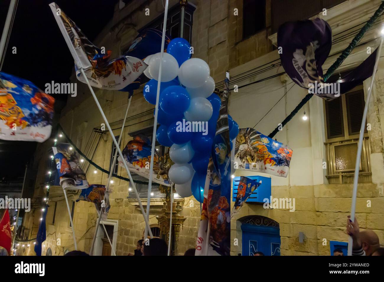 Cospicua, Malta - 6 dicembre 2024. Festa notturna di strada con palloncini blu e bianchi Foto Stock