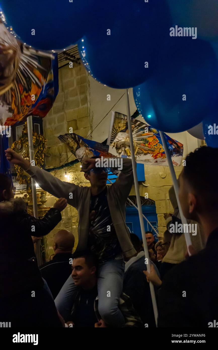 Cospicua, Malta - 6 dicembre 2024. Festa notturna di strada con palloncini blu e bianchi Foto Stock