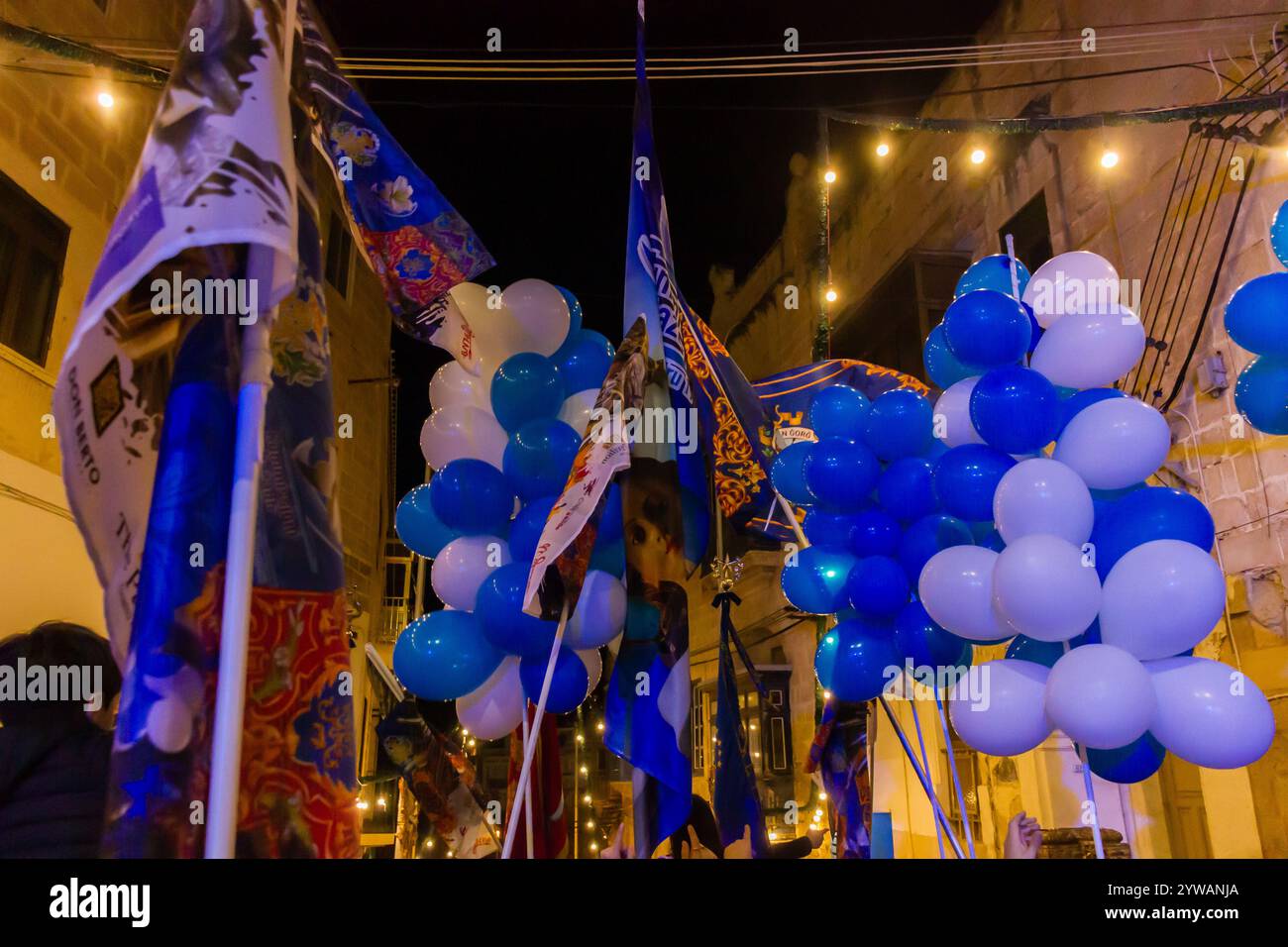 Cospicua, Malta - 6 dicembre 2024. Festa notturna di strada con palloncini blu e bianchi Foto Stock