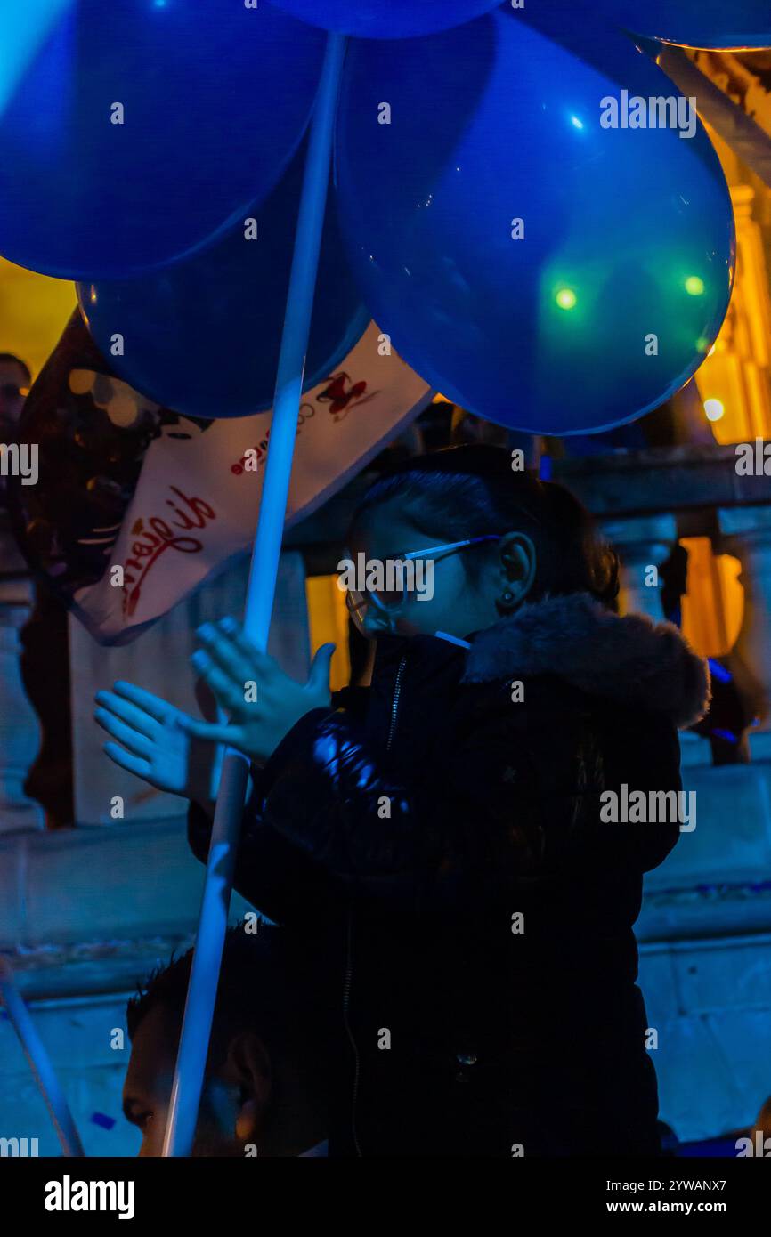 Cospicua, Malta - 6 dicembre 2024. Festa notturna di strada con palloncini blu e bianchi Foto Stock
