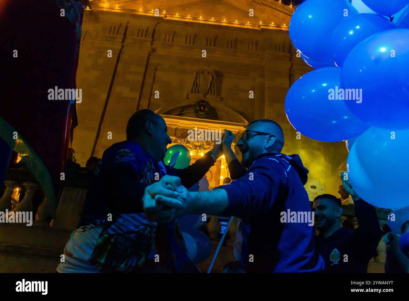Cospicua, Malta - 6 dicembre 2024. Festa notturna di strada con palloncini blu e bianchi Foto Stock