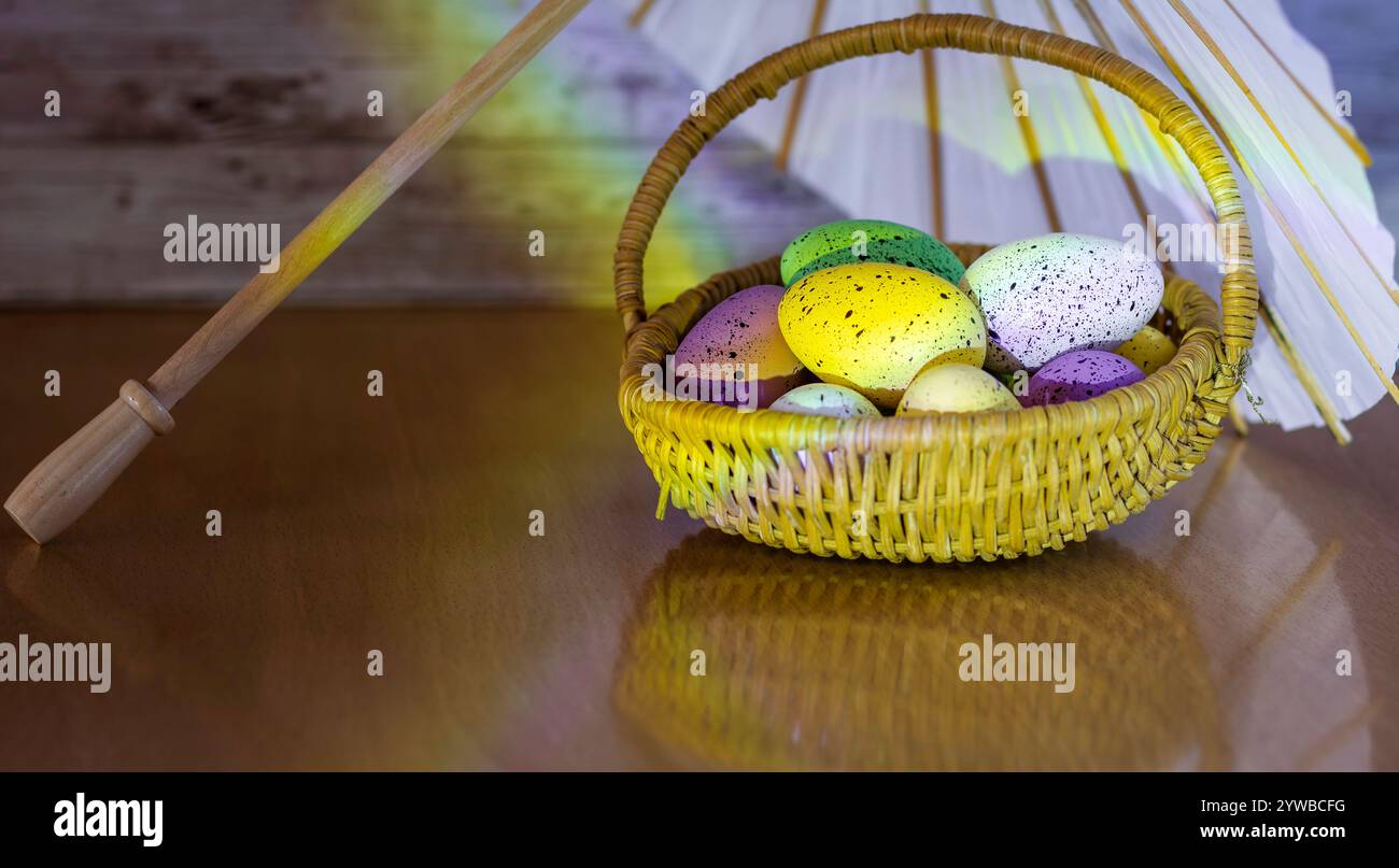 Uova colorate in un cestino sotto un ombrellone di carta, con una luce arcobaleno. Foto Stock Uova colorate in un cestino sotto un ombrellone di carta, con una luce arcobaleno. Foto Stock