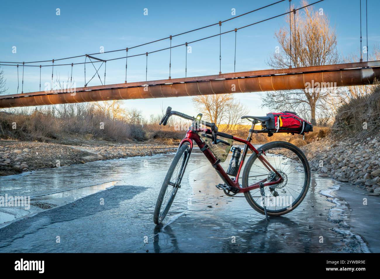 Tour in bicicletta sulla ghiaia su un rigoglioso fiume Poudre parzialmente ghiacciato a Fort Collins, Colorado Foto Stock