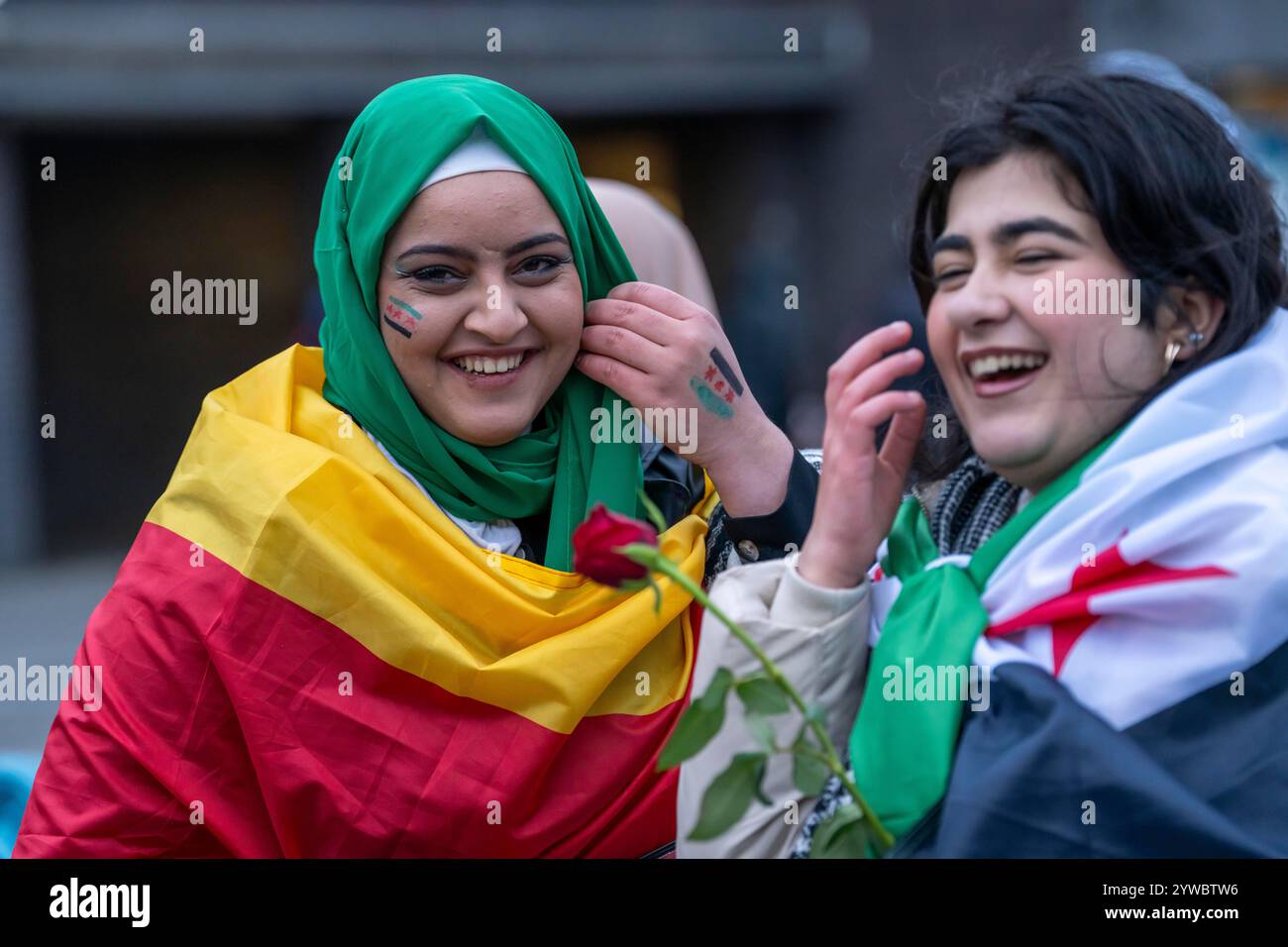 Le donne siriane celebrano la fine del regime di Assad dopo il cambio di potere in Siria, sul piazzale della stazione ferroviaria principale di Duisburg, Nord Foto Stock