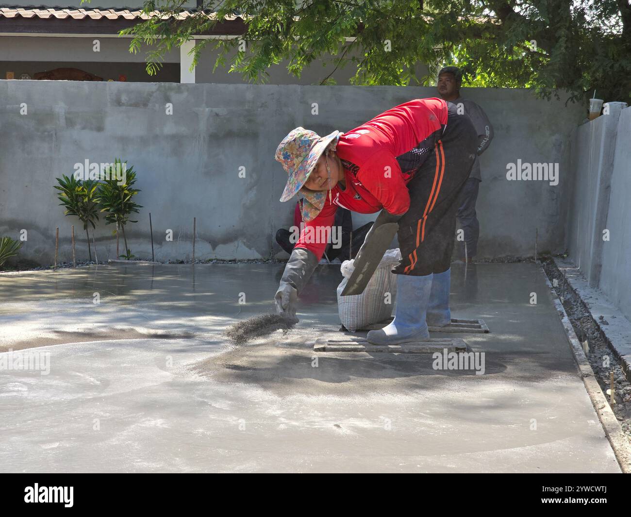 Pattaya, Thailandia 29 novembre 2024, un operaio qualificato applica meticolosamente una finitura decorativa al calcestruzzo appena versato. Foto Stock